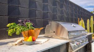 a kitchen counter with a grill and a bowl of vegetables at Blackhaus A Buyout by AvantStay 4-Room Retreat in Palm Springs