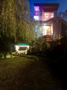 une maison avec une tour éclairée la nuit dans l'établissement Fairmont cottage Mukteshwar, à Mukteswar