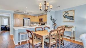 a kitchen and dining room with a wooden table and chairs at 504 Summerhouse by AvantStay Ocean Front Condo w Community Pool Access in Isle of Palms