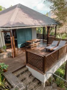 a wooden deck with a table and benches on it at Canopy House in Tamarin