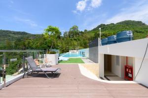 a balcony with a chair and a swimming pool at Fantasea Condo Kamala B211 2BDRM by Phuket Sabay Rent in Kamala Beach