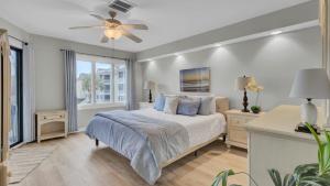 a bedroom with a bed and a ceiling fan at 202 D Port O Call by AvantStay Beach Condo in Isle of Palms +52 photos