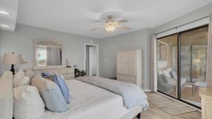 a white bedroom with a bed and a ceiling fan at 202 D Port O Call by AvantStay Beach Condo in Isle of Palms +22 photos