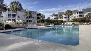 a swimming pool in front of some apartment buildings at 202 D Port O Call by AvantStay Beach Condo in Isle of Palms