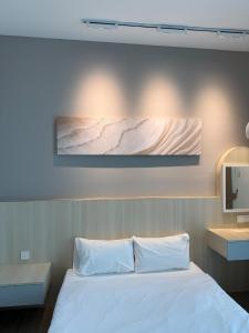 a bedroom with a bed and a painting on the wall at MC homes in Kota Kinabalu