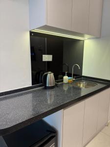 a kitchen counter with a sink and a mirror at MC homes in Kota Kinabalu