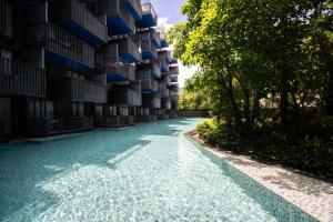 a swimming pool in front of a building at 新房特惠 芭东The Deck43精装一卧室公寓带浴缸 近芭东海滩Bangla江西冷 in Patong Beach