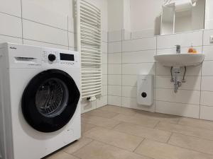 a white laundry room with a washing machine and a sink at Apartment Mühlentor Am Wariner See in Warin