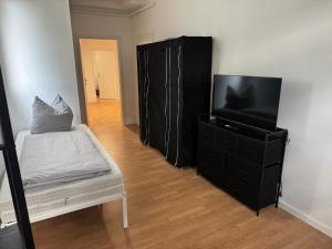 a living room with a black dresser and a flat screen tv at Apartment Mühlentor Am Wariner See in Warin +7 photos