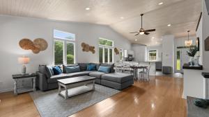 a living room with a couch and a table at Coves End by AvantStay Dock Game Room Fire Pit Forest Views in Mooresville