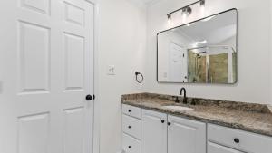 a white bathroom with a sink and a mirror at Coves End by AvantStay Dock Game Room Fire Pit Forest Views in Mooresville +35 photos