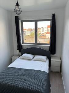 a bedroom with a bed and a large window at Stylish, modern & spacious apartment in Brussels in Brussels