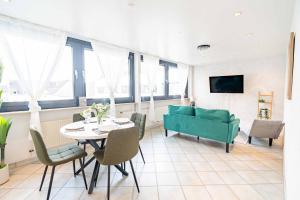 ein Wohnzimmer mit einer grünen Couch und einem Tisch in der Unterkunft City Wohnung am Hbf mit 2 Schlafzimmern und Sky in Koblenz