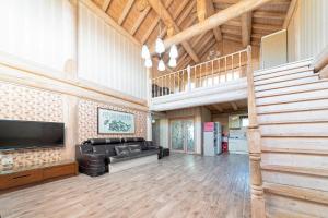 a living room with a couch and a flat screen tv at Ganghwa Izba Pension in Incheon