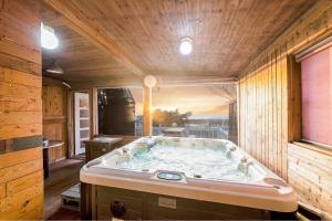 a jacuzzi tub in a room with a window at Ganghwa Izba Pension in Incheon +3 photos