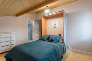 Un dormitorio con una cama con almohadas azules. en Maison Xara-heguia, en Hasparren