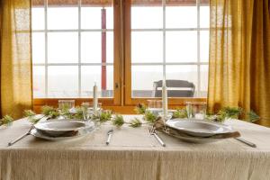 a table with two plates and candles on it at Frosty Brook Cottage Hosted by Hygge Host in Lehtola