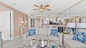 a living room with a couch and a ceiling fan at Beachfront Breeze by AvantStay Beachfront Condo in Panama City Beach