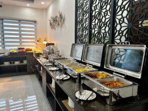 a buffet line with many trays of food at Dawn Garden Luangprabang Hotel in Luang Prabang