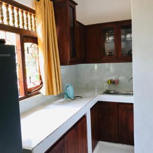 a kitchen with wooden cabinets and a sink and a window at T N D House in Habaraduwa Central +50 photos