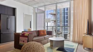 ein Wohnzimmer mit Couch und großem Fenster in der Unterkunft 2 Condos Brand New Austin High Rise w Rooftop Pool Gym Yoga Studio More in Austin