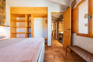 - une chambre avec un lit et un banc dans l'établissement Mas Del Sanco, à Sierra-Engarcerán