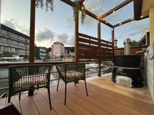 Dos sillas y una parrilla en una terraza con vista. en UMI&kanzanji, en Hamamatsu