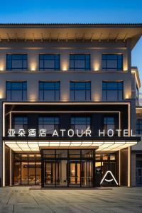 an exterior view of an apartment building with an arrow hotel at Atour Hotel Pengbo Central Plaza Lanzhou Zhongchuan Airport in Lanzhou