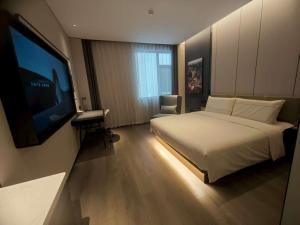 a hotel room with a bed and a flat screen tv at Atour Hotel Pengbo Central Plaza Lanzhou Zhongchuan Airport in Lanzhou +7 photos
