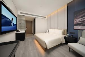 a hotel room with a bed and a tv at Atour Hotel Pengbo Central Plaza Lanzhou Zhongchuan Airport in Lanzhou