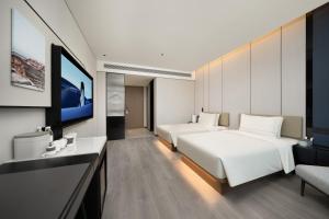 a hotel room with two beds and a flat screen tv at Atour Hotel Pengbo Central Plaza Lanzhou Zhongchuan Airport in Lanzhou