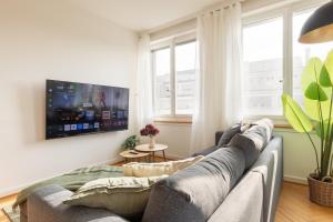 a living room with a couch and a tv at Spacious City View Apartment - Prime Location Biel in Biel