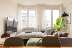 a bedroom with a bed and a couch in front of a window at Spacious City View Apartment - Prime Location Biel in Biel