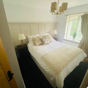 a white bed in a bedroom with a window at The Hideaway in Sutton Scotney