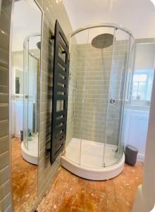 a bathroom with two mirrors and a shower at The Hideaway in Sutton Scotney
