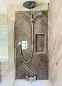 a shower in a bathroom with a tile wall at The Hideaway in Sutton Scotney