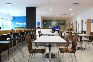 a dining room with tables and chairs in a store at One Guadalajara Tapatio in Guadalajara