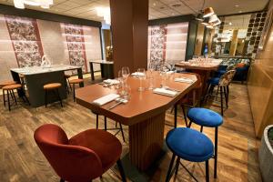 a dining room with tables and chairs with wine glasses at Crowne Plaza Padova by IHG in Padova