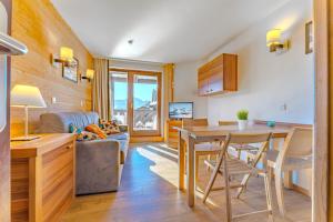 Una cocina y una sala de estar con una mesa y un sofá. en Feel the mountains at Machu; 5 people, en Val Thorens