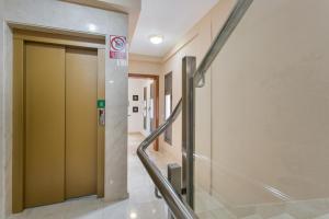 El GuinchoにあるApartamento Rolycar 201の病院の廊下にあるガラスのドアが付いたエレベーター