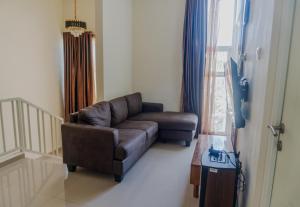 a living room with a brown couch and a window at Villa Exotic 22 Batu in Tlekung