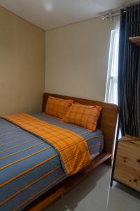 a bedroom with a bed with an orange blanket at Villa Exotic 22 Batu in Tlekung