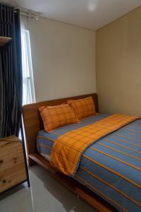 a bedroom with a bed with an orange blanket and a window at Villa Exotic 22 Batu in Tlekung