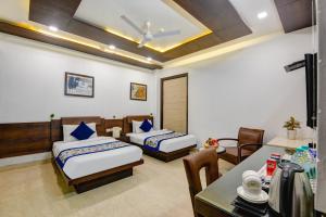 a bedroom with two beds and a table and chairs at Qotel Signature Lavish Rajouri Garden New Delhi in New Delhi +123 photos