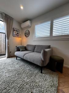 a living room with a couch and a window at Remarkables Escape in Queenstown Airport