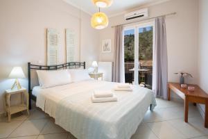a bedroom with a bed with two towels on it at Levanda Cozy Apartments in Lefkada