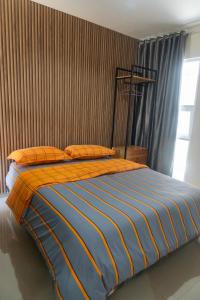 a bed with an orange and blue comforter in a bedroom at Villa Exotic 22 Batu in Tlekung