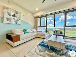 a living room with a white couch and large windows at Iskandar Residence by RR JBcity in Nusajaya
