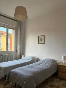 a bedroom with two beds and a window at Alfano Apartment in Bologna
