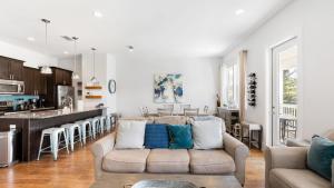 a living room with a couch and a kitchen at Seacrest Paradise by AvantStay Steps to the Beach Pet Friendly in Destin